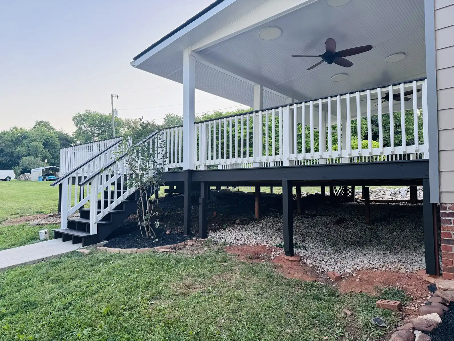 Deck and covered porch stained dark gray with white railings