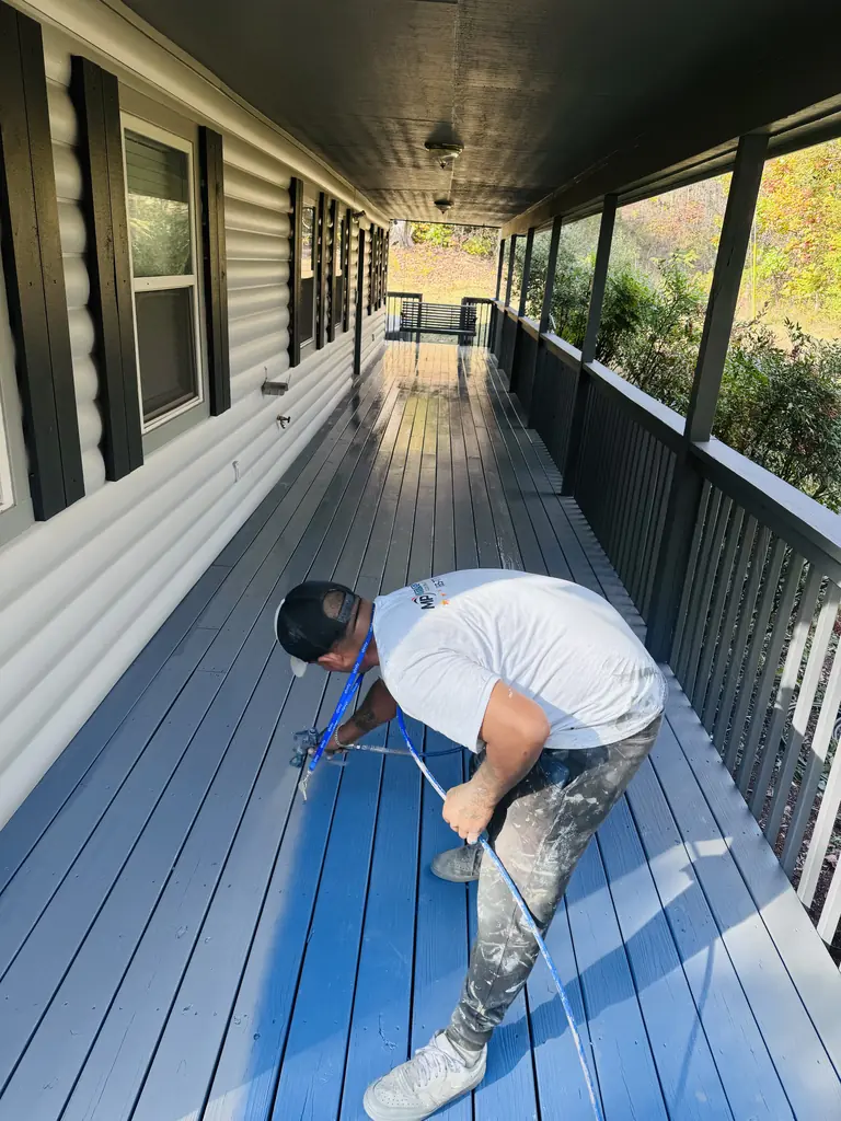 Master Painting painter coating a covered porch floor