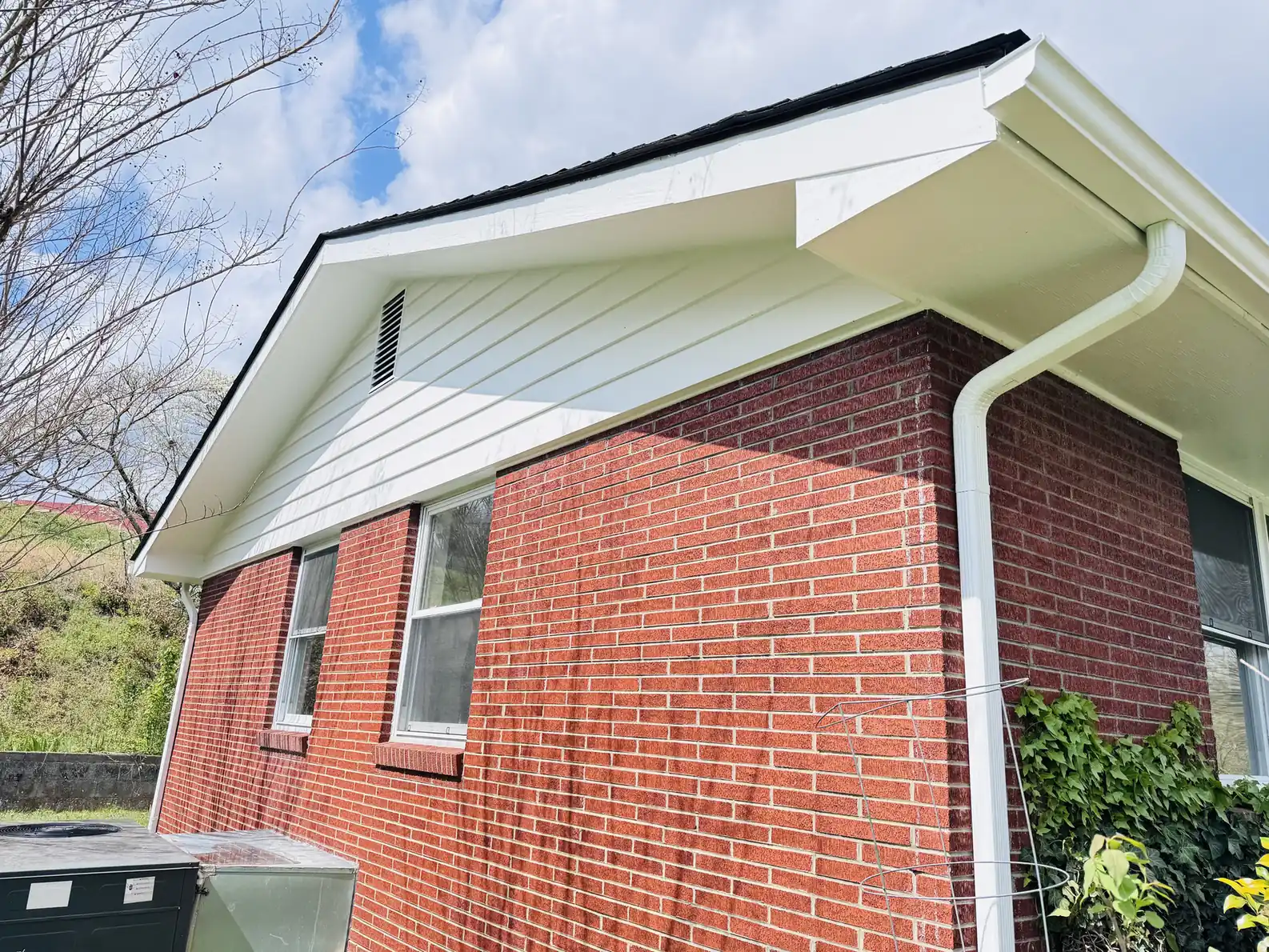 Brick home with freshly painted white trim and gable